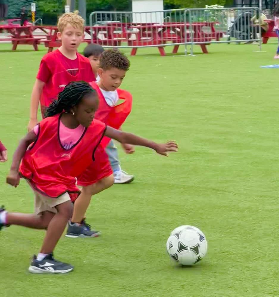 Children playing soccer outdoors at camp